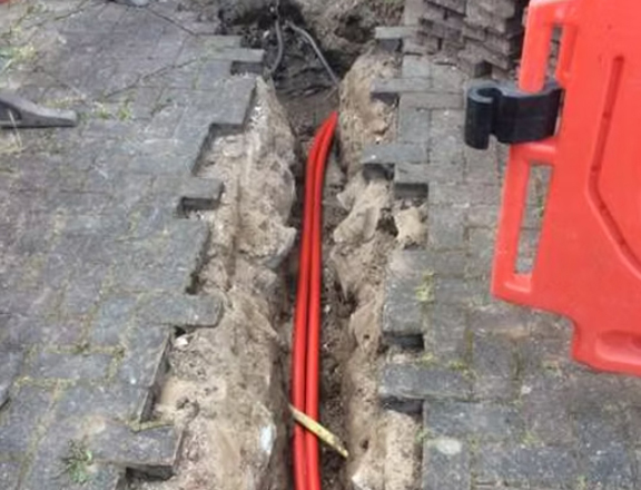 excavations in ground with cables being layed